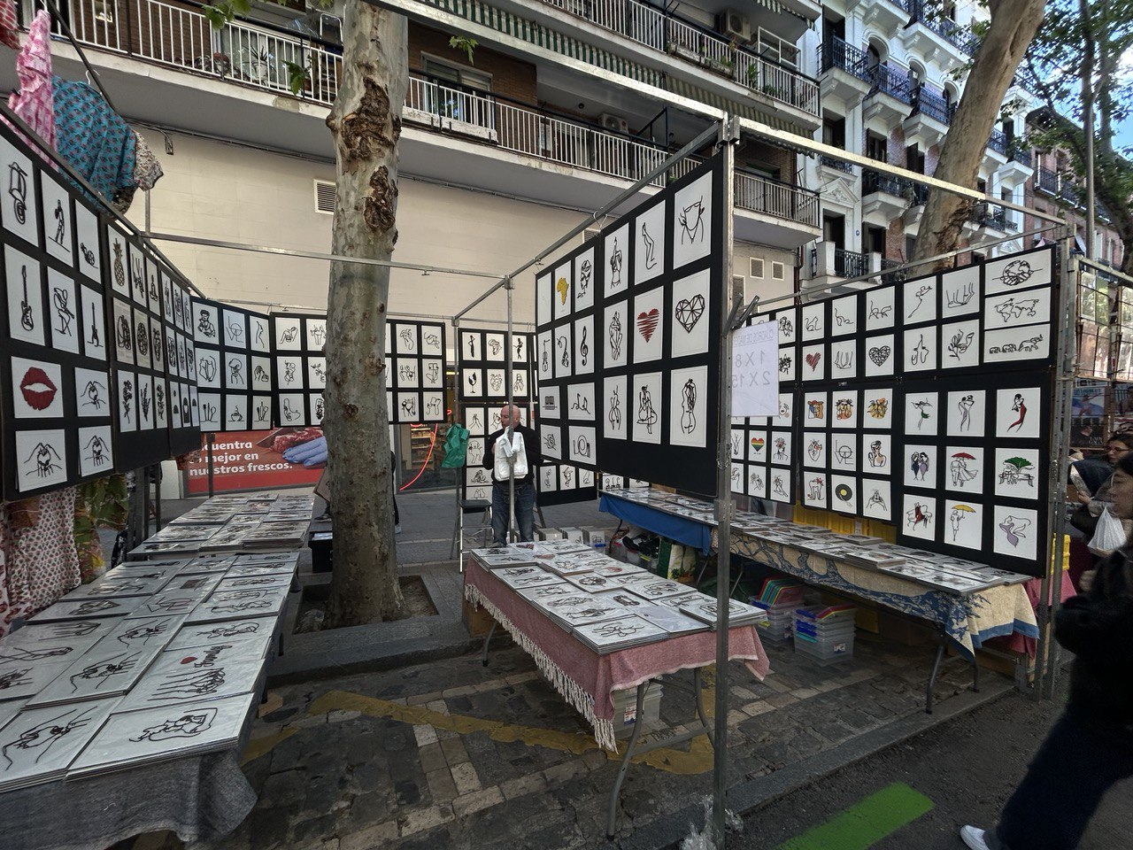 Stra&szlig;enk&uuml;nstlerstand mit hunderten kleinen gerahmten Zeichnungen und Illustrationen an Stellw&auml;nden unter Zeltdach