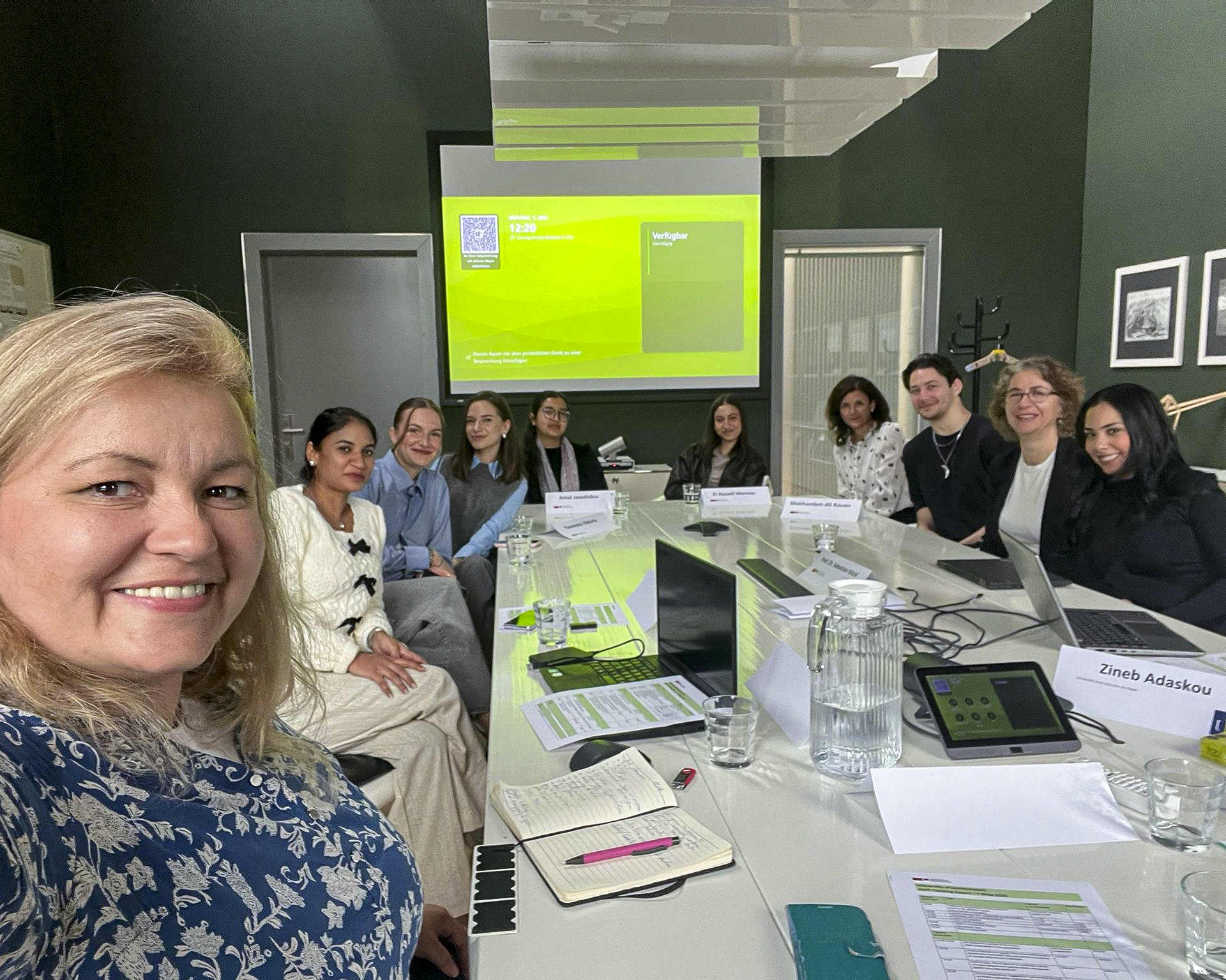 Selfie von mehreren Personen, die an einem Besprechungstisch sitzen