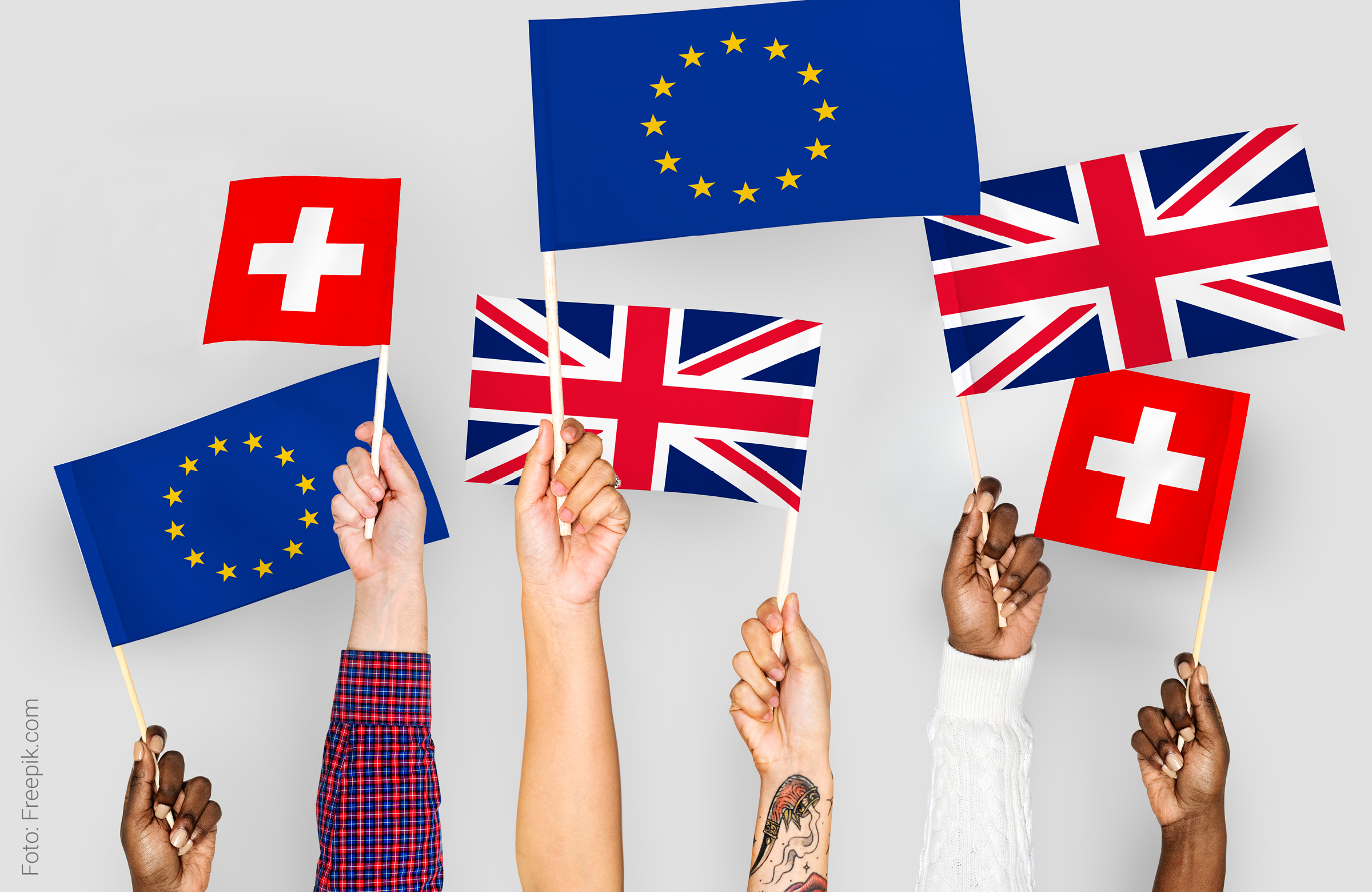 Sechs Hände halten kleine Fahnen der EU, Schweiz und dem Vereinigten Königreich hoch