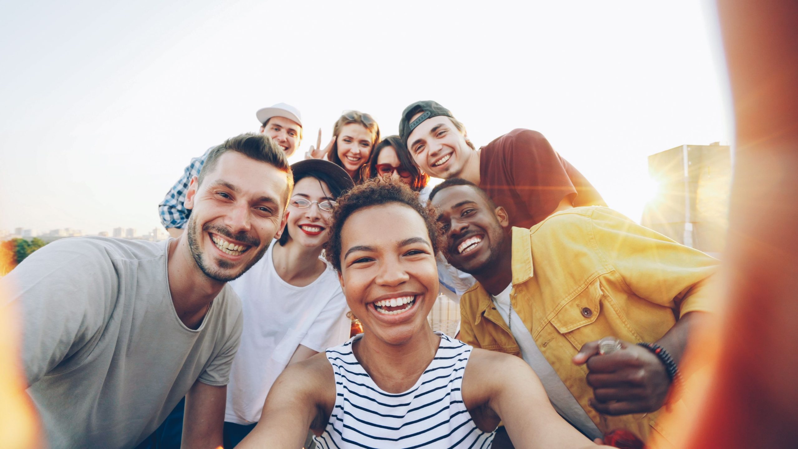 Gruppe junger Menschen macht ein Selfie und lacht in die Kamera