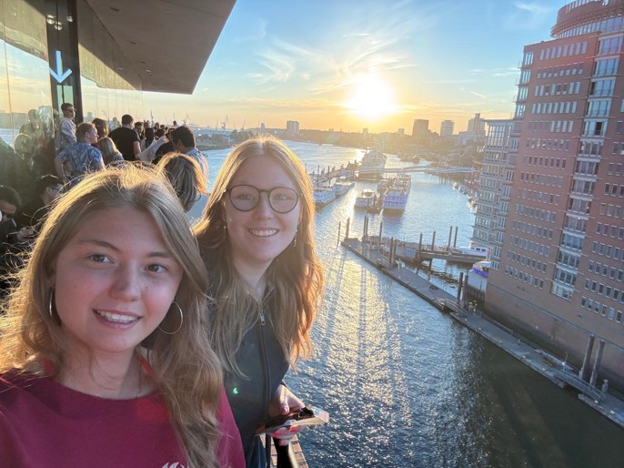 Zwei DiscoverEU-Reisende stehen auf der Terrasse der Elbphilharmonie, im Hintergrund ist der Sonnenuntergang zu sehen