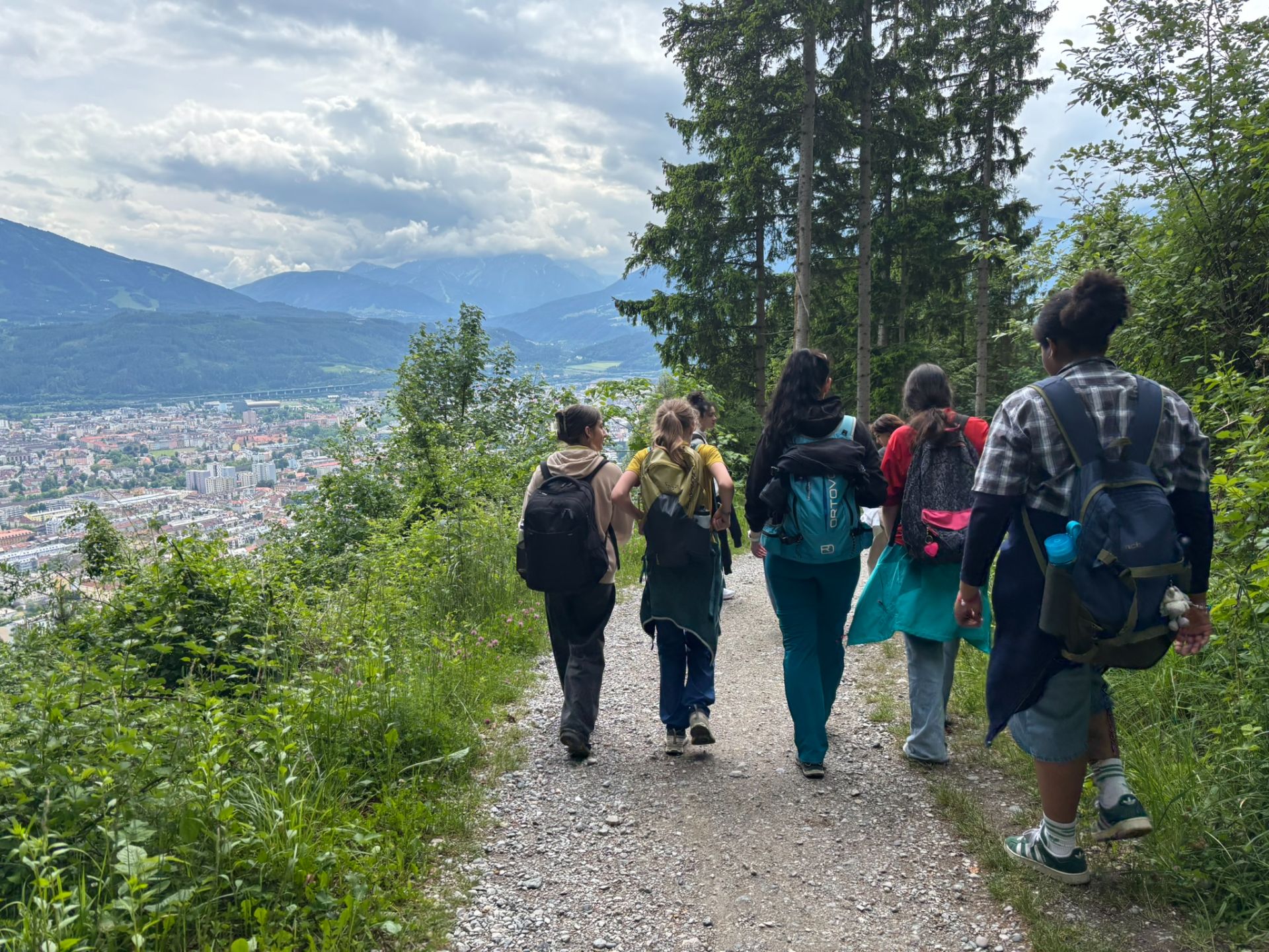 Gruppe von Sch&uuml;lern geht auf einem Weg, im Hintergrund ist eine Stadt zu sehen